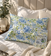Load image into Gallery viewer, Floral-patterned pillow on a bed with a Thomas & Lee packaging.
