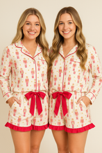 Load image into Gallery viewer, Two women wearing matching pajama sets with red ribbons on a beige background