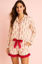 Load image into Gallery viewer, Woman wearing a pajama set with a red bow on a pink background