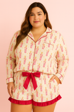 Load image into Gallery viewer, Woman wearing a pajama set with a pink bow on a pink background
