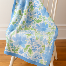 Load image into Gallery viewer, Floral patterned blanket draped over a chair with a white background
