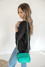 Load image into Gallery viewer, A woman wearing a denim shirt is showcasing a small quilted crossbody bag with a gold chain strap.
