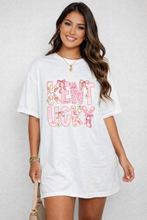 Load image into Gallery viewer, Woman wearing a white t-shirt with 'Kentucky' printed in colorful letters on a plain background
