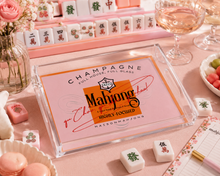 Load image into Gallery viewer, Maison Mahjong packaging on a pink table with mahjong tiles and glasses.
