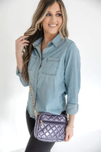Load image into Gallery viewer, A woman wearing a denim shirt is showcasing a small quilted crossbody bag with a gold chain strap.
